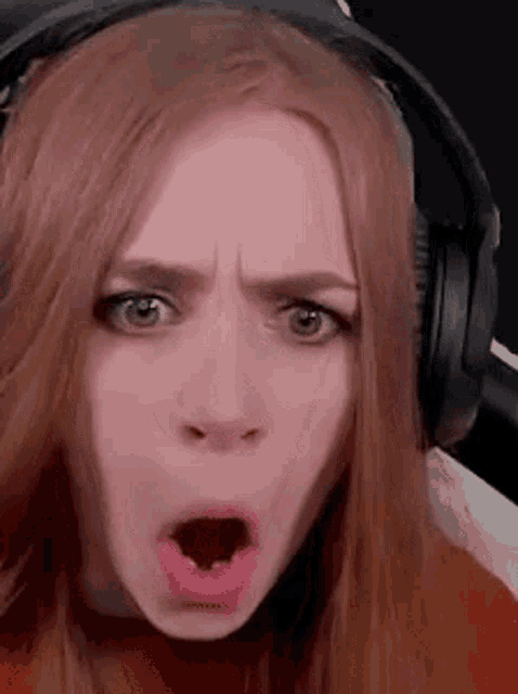a woman wearing headphones is making a funny face .