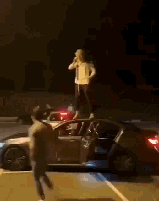 a man is standing on the back of a car