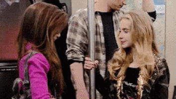 a man and a woman are standing next to each other on a subway train .
