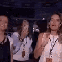 a group of women are standing next to each other in a crowded room .