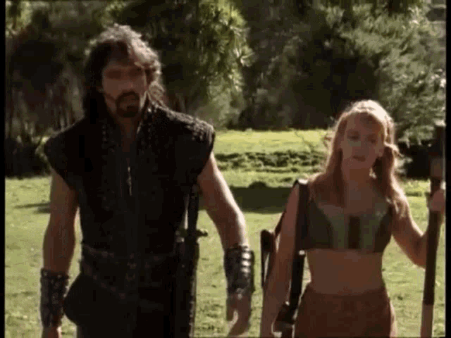 a man and a woman are walking through a field