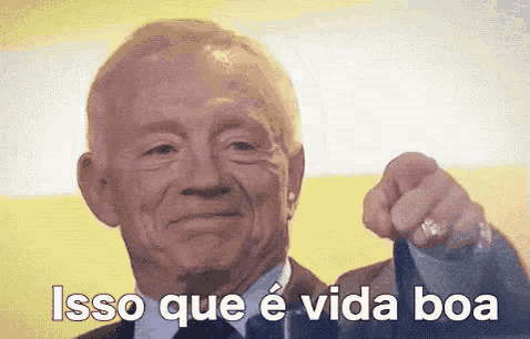 a man in a suit and tie is pointing at the camera and saying isso que e vida boa .