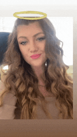 a woman with long curly hair has a golden halo on her head