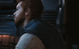 a man with a beard is standing in a dark room looking at something
