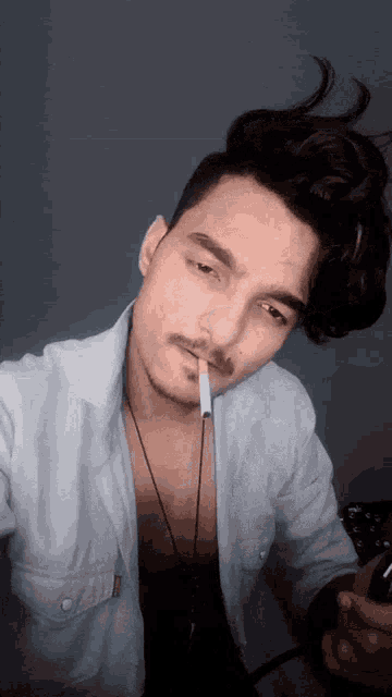 a man with a cigarette in his mouth takes a picture