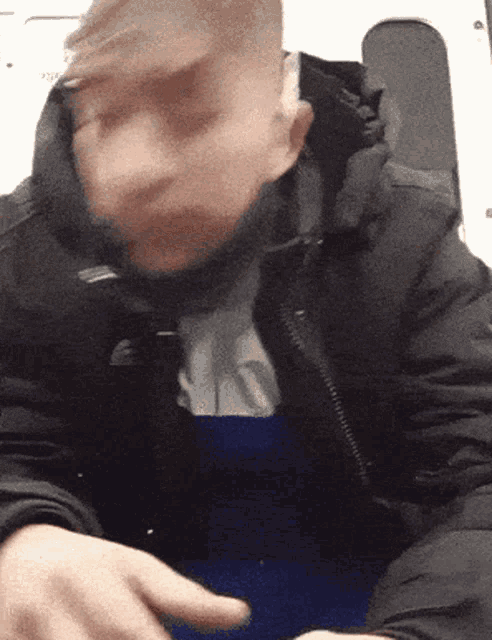 a blurry picture of a man 's face with a blue shirt underneath