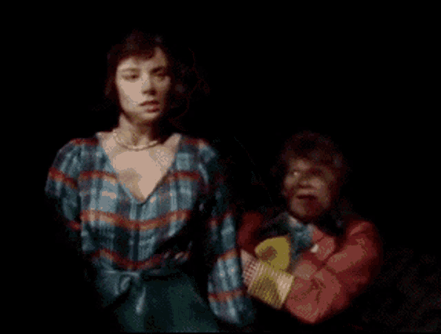 a woman in a plaid shirt stands next to another woman in a red jacket