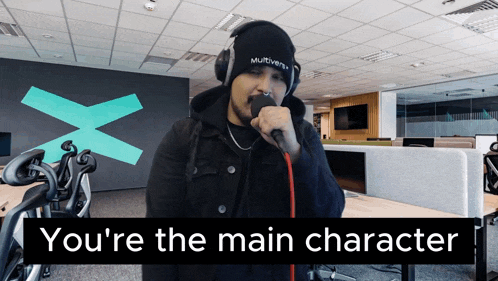 a man singing into a microphone with the words " you 're the main character " on the bottom