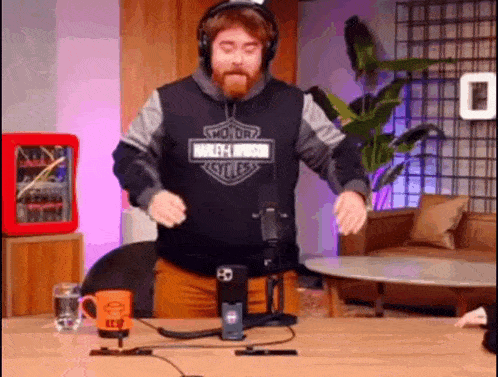 a man wearing headphones is dancing in front of a microphone in a room .