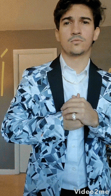 a man with a ring on his finger is wearing a blue jacket