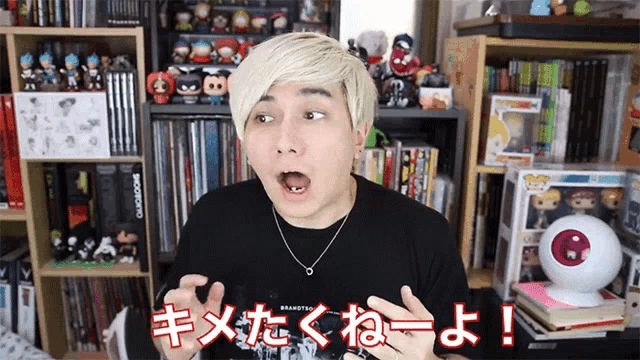 a man in a black shirt has a surprised look on his face in front of a bookshelf