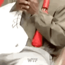 a man in a suit and tie is holding a cell phone .