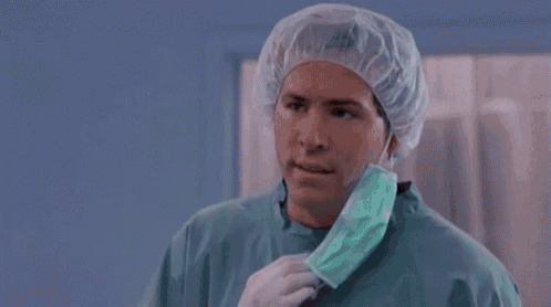 a man wearing a surgical gown and a mask is asking but why .