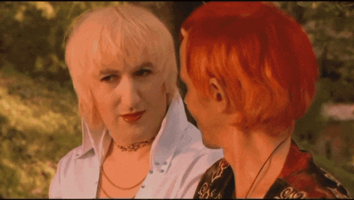 a woman with blonde hair and red hair looks at another woman with red hair
