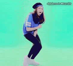 a girl with a beard is dancing on a green background