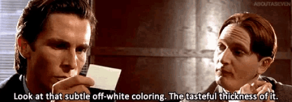 two men are looking at a piece of paper and one of them says look at that subtle off-white coloring