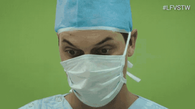 a close up of a surgeon wearing a mask and making a funny face