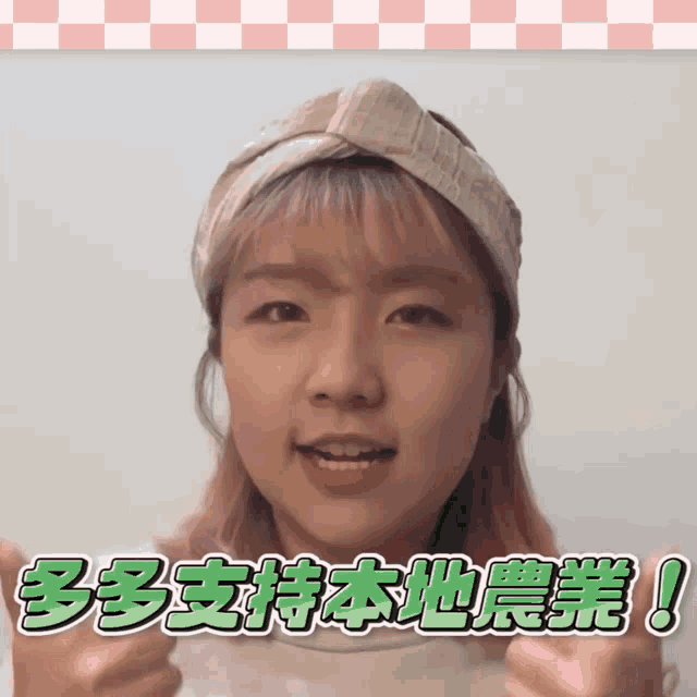 a girl with pink hair is wearing a headband and giving a thumbs up