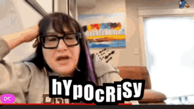 a woman wearing glasses says hypocrisy on a video call