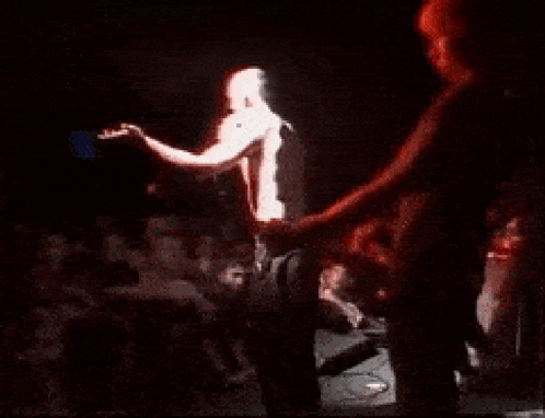 a man singing into a microphone on stage in front of a crowd of people