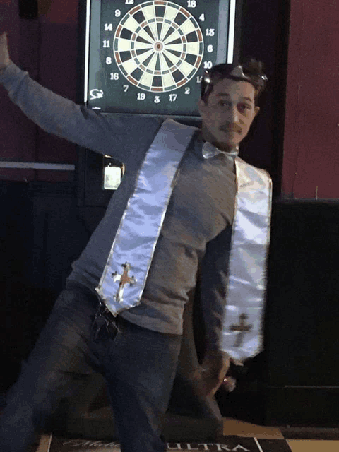 a man standing in front of a dart board that says ultra on the floor