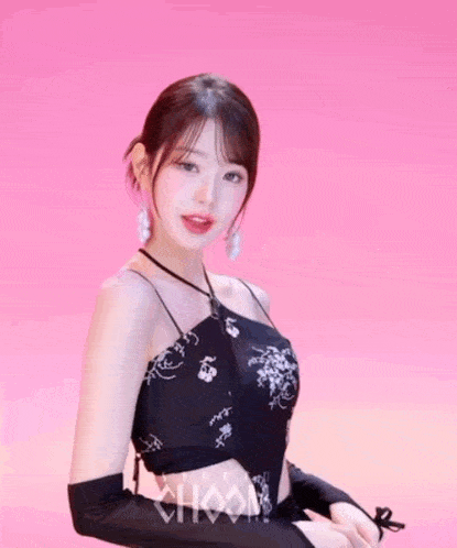 a woman stands in front of a pink background that says studio chaam on it