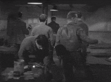 a black and white photo of a man in a room on fire