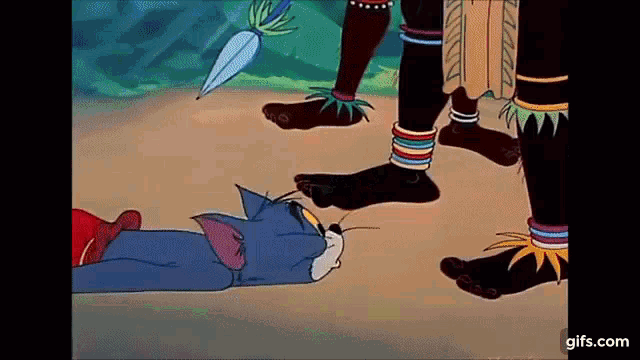 a cartoon of a cat laying on the ground next to a group of people 's feet .