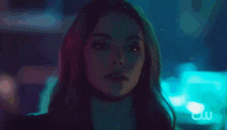 a close up of a woman 's face in a dark room with blue lights .