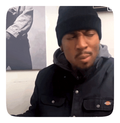 a man wearing a black jacket and a black beanie with the word dickies on it