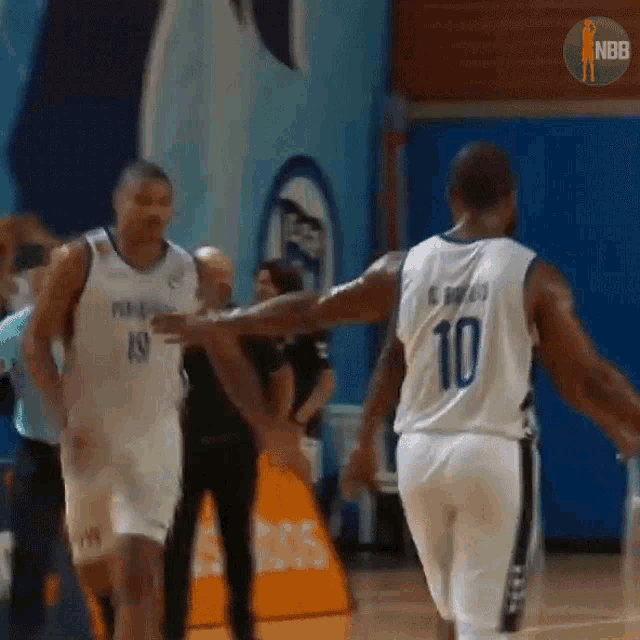 a basketball player with the number 10 on his jersey talks to another player