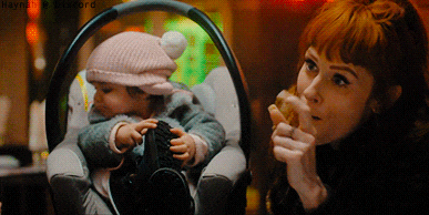 a woman is holding a baby in a car seat with a watermark that says haynes on it