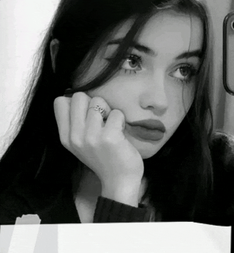 a black and white photo of a woman with a ring on her finger that says evil