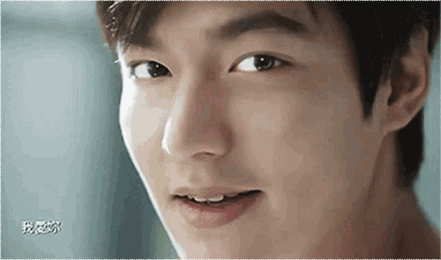 a close up of a young man 's face with chinese writing in the background
