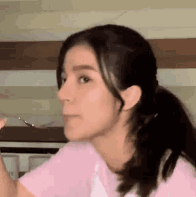 a woman in a pink shirt is making a funny face .