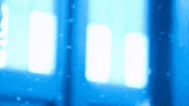 a blurry picture of a window with snow falling in the background