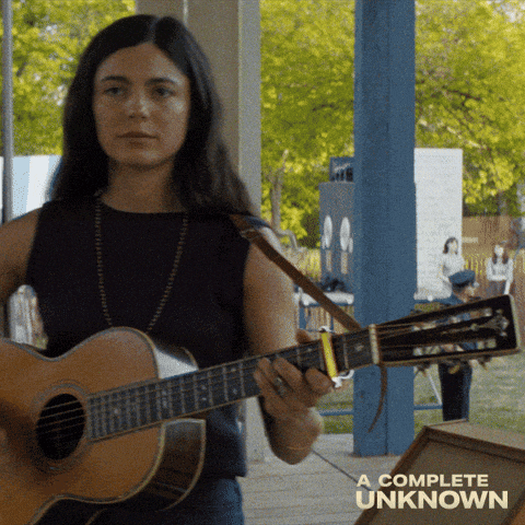 a woman playing a guitar with the words a complete unknown on the bottom