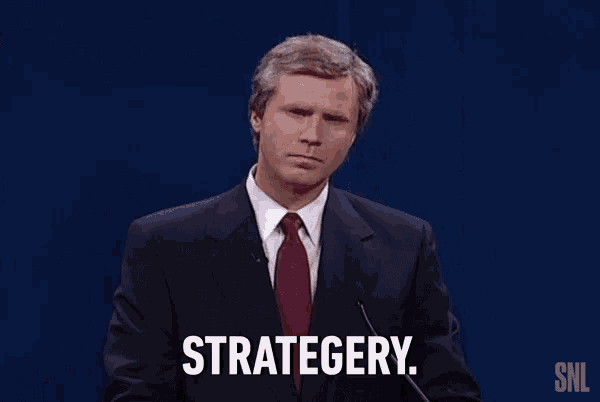 a man in a suit and tie stands in front of a microphone and says strategy