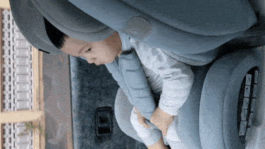 a baby is sitting in a car seat with a warning label on the back