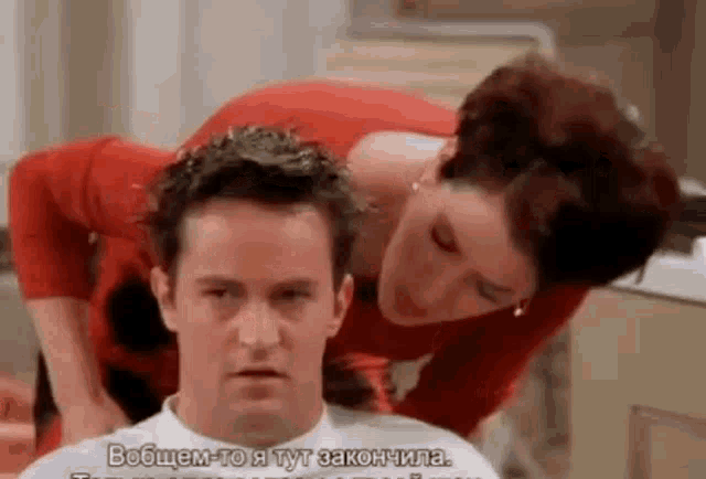 a woman is looking at a man 's hair in a barber shop .