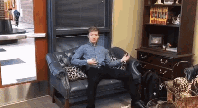 a man sitting on a couch with a glass of wine