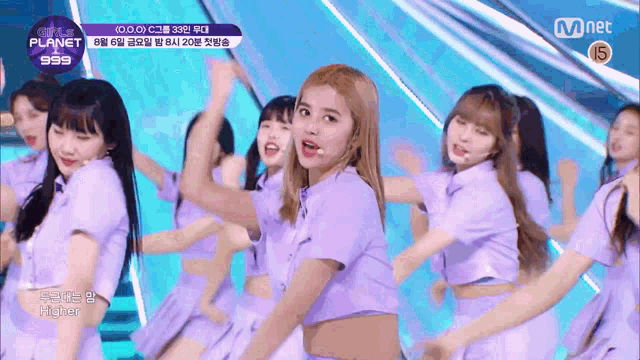a group of girls in purple dresses are dancing on a stage