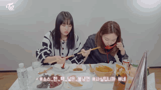 two girls sitting at a table eating food with a twice logo in the corner