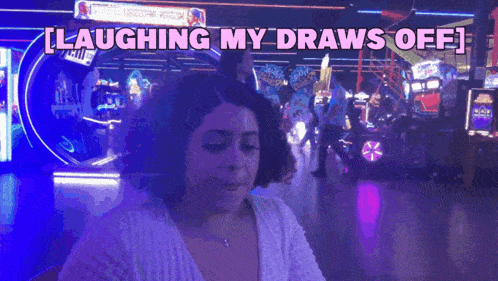 a woman is laughing while playing an arcade game