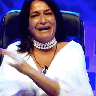 a woman wearing a choker and pearls is sitting in a chair