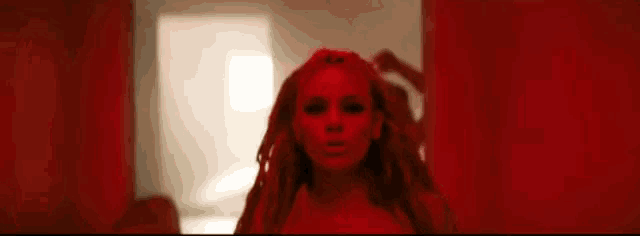 two women are standing next to each other in a dark room in a red light .