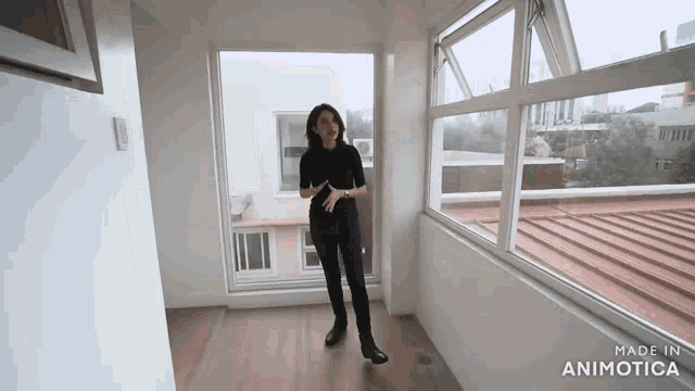 a woman is standing in an empty room with the words made in animatica on the bottom right