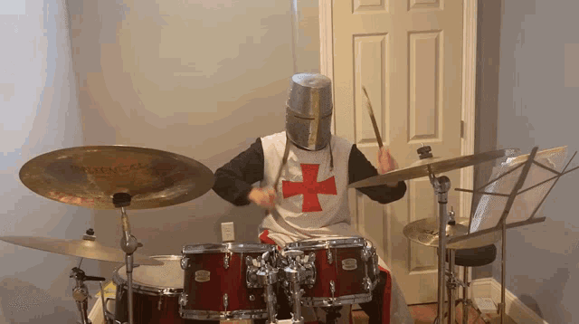 a man in a knight 's helmet is playing a drum set