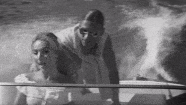 a man and a woman are riding on a boat in the water