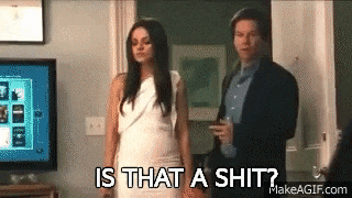 a woman in a white dress is standing next to a man in a suit and asking is that a shit ?